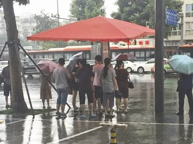 下雨天公交车站避雨1jk人们在等车时寻找遮蔽处躲避雨水